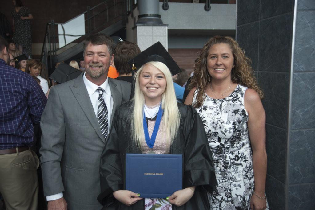 A new graduate posing with her family.