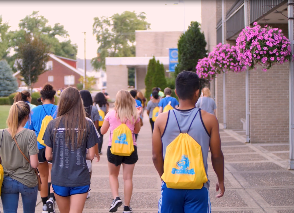 Group of students walking outside of the Moore Center in the Quad.